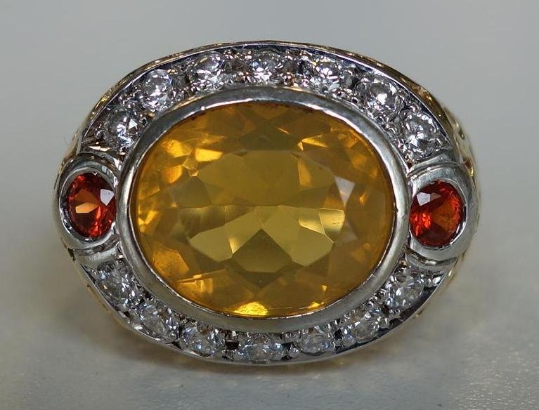 4.5ct Brazilian Fire Opal & Diamond 14K Gold Ring: 14K gold ring set with a large 4.5ct Brazilian fire opal, surrounded by 14 full cut VS, G color diamonds. The opal flanked on each side by a red-orange garnet. Ring size 4.25. Overall weight 10 grams.