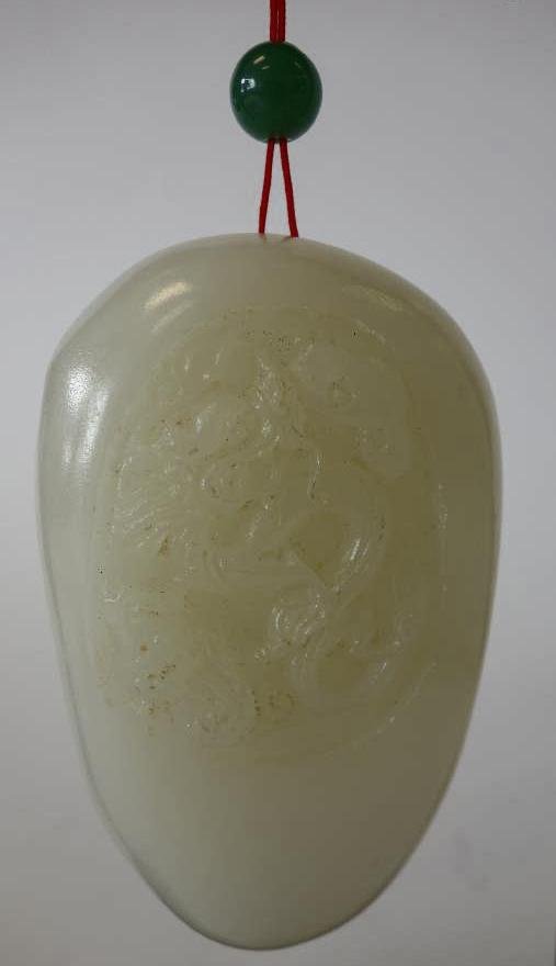 Chinese Carved White Jade Boulder: Chinese white jade boulder. Carved on one side depicting a dragon. Held in a wood stand with a jadeite jade bead. The boulder measures 3.25" x 2". Overall height of stand, 7".