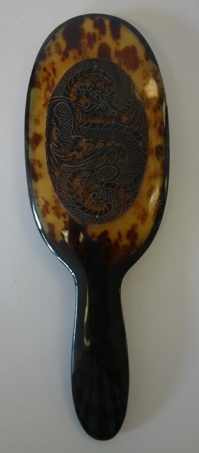 Chinese Tortoiseshell Brush Cover: Chinese tortoiseshell hair or clothes brush cover with handle. Carved dragon motif. Measures 9" long and 3" wide. Could also be used as a mirror.