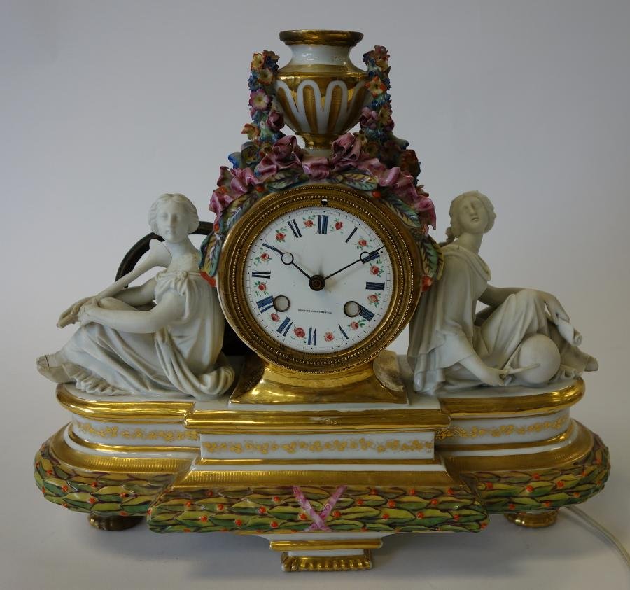 French Porcelain Mantel Clock Dechevaux Dumesnil: A French porcelain and parian mantel clock. The enameled clock face marked Dechevaux - Dumesnil. Two female parian / bisque Greco-Roman figures flank each side. Measures 11.75" high, 14" wide and 5.5"
