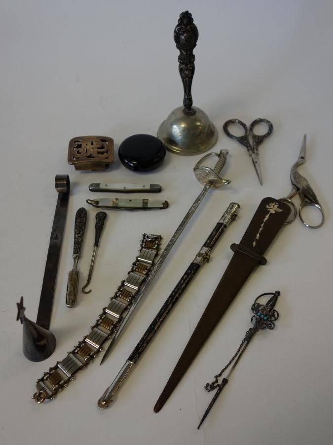 Letter Openers, Scissors, Pocket Knives +: Misc. grouping. Includes a dinner bell, 2 letter openers (one a US Navy sword-formed letter opener), 2 mother of pearl pocket knives, 2 pair of scissors, a candle snuffer, lapel pin, belt buckle, etc.