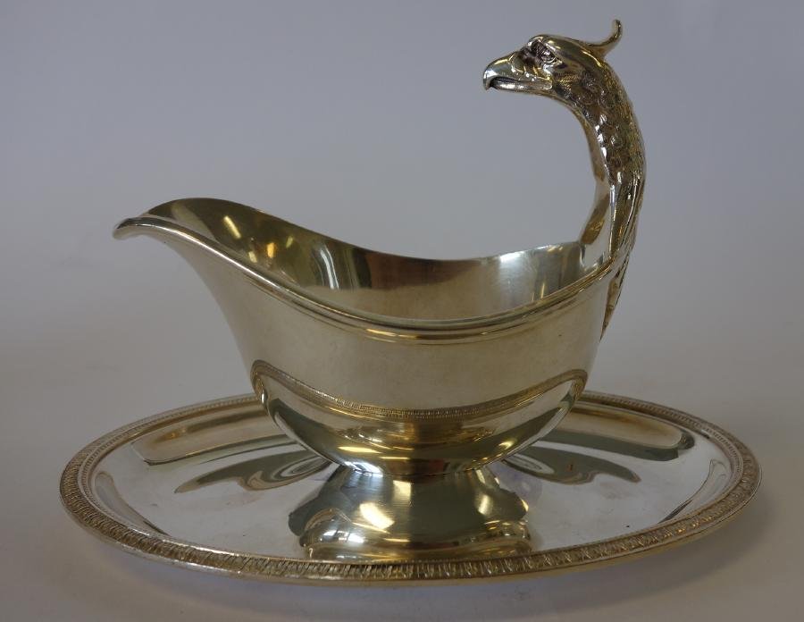 Christofle Silver Plate Gravy Boat, Griffin Handle: A silverplate sauce / gravy boat by Christofle, France. Stylized griffin formed handle. Attached underplate with acanthus leaf motif border. Measures 8.75" x 5.5" x 6.25" high. Signed on the underside