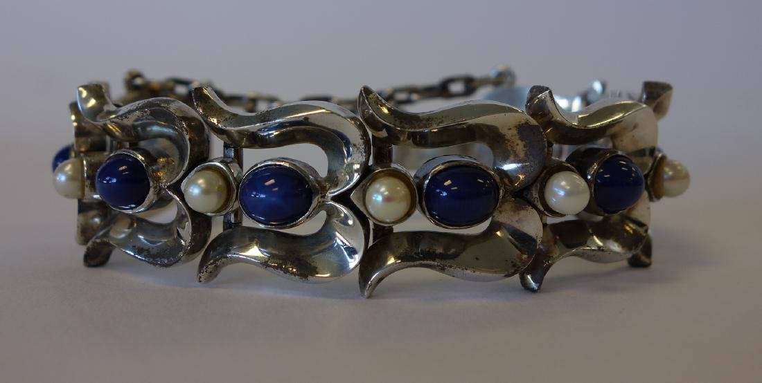 Sterling & Star Sapphire Modernist Mexican Bracelet: A sterling 970 silver Mexican bracelet. Modernist design. Set with 8 synthetic blue star sapphires, alternating with 8 natural cultured pearls. Similar in design and structure to Antonio Pineda. Hallm
