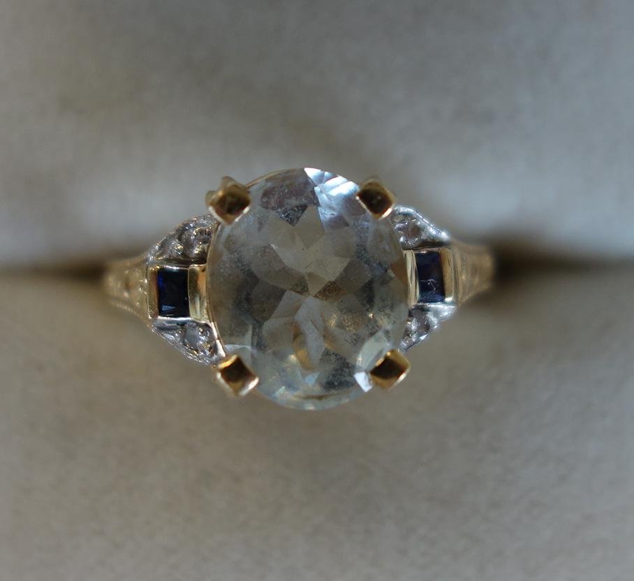 Art Deco Aqua Marine 14K Gold Ring: An Art Deco 14K gold ring, set with a faceted white aqua marine center stone, flanked on each side with a natural sapphire and two individually cut diamonds. Weighs 3.6 grams. Ring size 6.