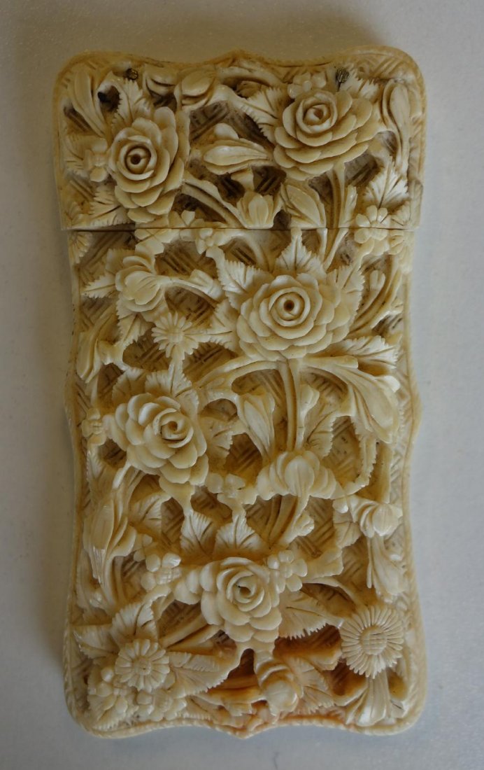 Chinese Carved Ivory Card Case, Flowers & Figures: A Chinese ivory calling card case. Finely carved. The front with raised in relief leaves and flowers. The backside carving is within an urn shaped cartouche depicting a scene from mandarin life. Measu