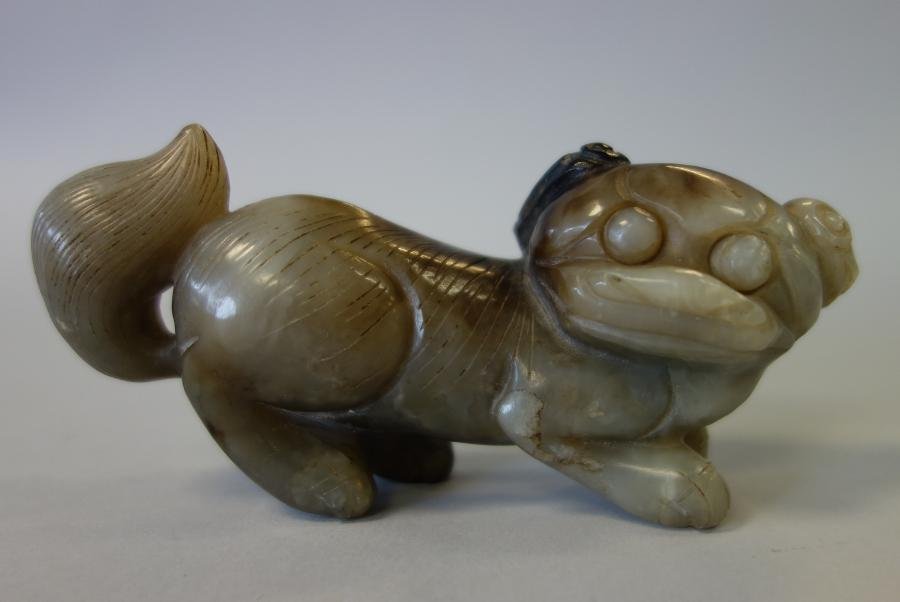 Chinese Nephrite Jade Foo Dog Carving: A Chinese nephrite jade carving of a foo dog or lion. Measures 4.75" long, 1.25" wide and 2-3/8" high.