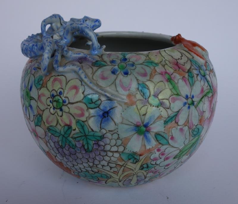 Chinese Millefiori Porcelain Dragon Bowl, signed: A Chinese porcelain bowl or vase. c. 1900. Overall millefiori flower motif. Raised dragon and bat at shoulder. Measures 5.25" in diameter and 4" high. Signed underfoot with a red seal reign mark.