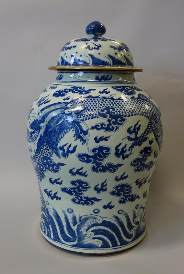 Chinese Porcelain Palace Size Temple Jar: A Chinese porcelain lidded temple jar. 19th century. Large palace size jar measuring 23.75" high and 15.5" in diameter at the widest point on the body. Underglaze blue and white four-claw dragon and c