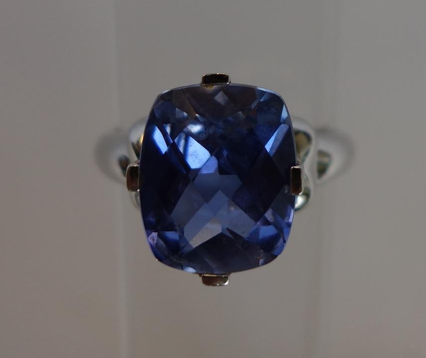 Blue Topaz & White Gold Ring: A large faced blue topaz stone (tanzanite in color), set in a 10K white gold ring. Weighs 3.5 grams. Ring size 7.