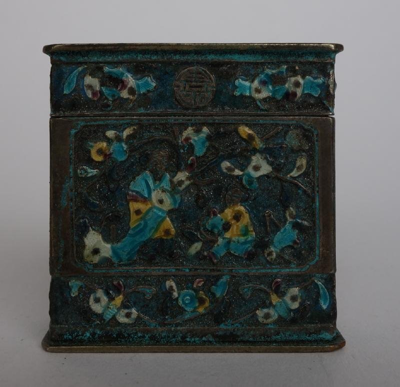 Chinese Silver & Enamel Box, Signed: A Chinese silver box. Rectangular shaped box with lid. Overall raised enamel decoration depicting a figure in a garden setting, bats, flowers and Chinese symbols. Signed on the underside. Measures 1.5