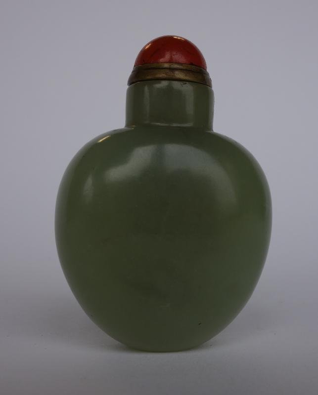 Chinese Nephrite Jade Snuff Bottle: A Chinese nephrite jade snuff bottle. Carnelian cap. Measures 2.25" high.