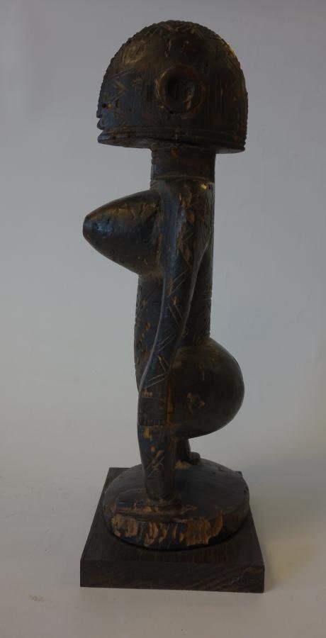 African Bambara Tribe Nude Fertility Figure: An African wood carving, Bambara tribe, ex. French Sudan. This carving of a nude female represents a fertility figure with exaggerated breasts and buttocks. The head and body highly abstracted and cov