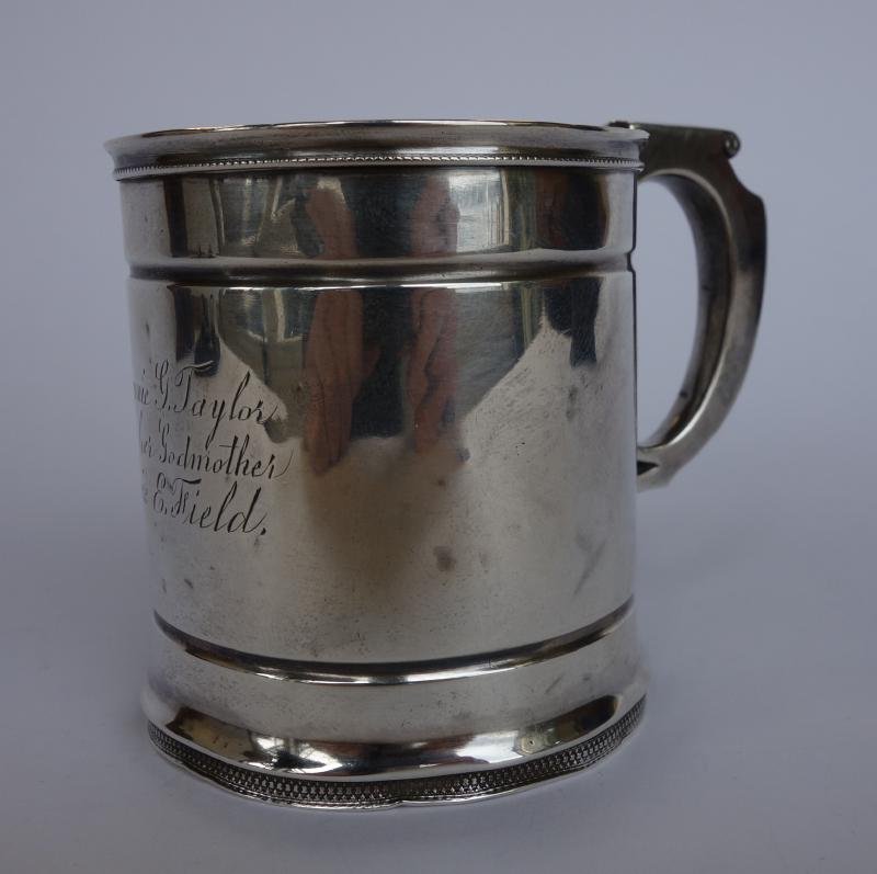 Sterling Child's Cup, Wood & Hughes, New York: An American sterling silver child's cup or mug. Marked on the underside for maker's Wood & Hughes, New York. Engraved Minnie G. Taylor from her Godmother Minnie E. Field. Measures 3" high and 3.75" wi