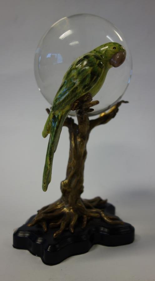 Crystal Ball & Holder, Enamel Parrot & Bronze Tree: A crystal ball and holder. Bronzed metal base modeled as a tree, with an enamel painted parrot perched on a branch. Measures 9.25" high. The crystal ball measures 3.75" in diameter and rests in the br