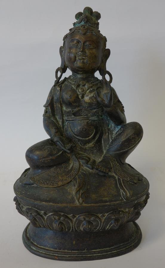 Large Bronze Model of Goddess Tara: A bronze model of the Goddess Tara. Well detailed sitting female figure resting on an oval lotus formed base. Measures 11.25" high, 6.25" wide and 4.75" deep.