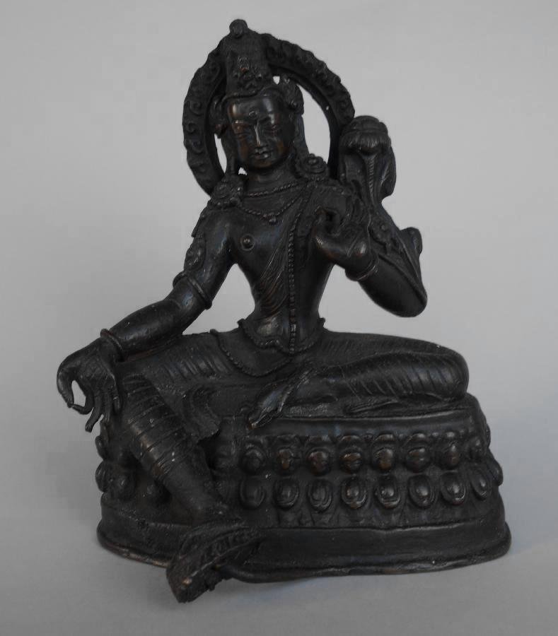 Bronze Model of Goddess Sita White Tara: A bronze model of the Goddess Sita (white) Tara. The female figure sits with one leg crossed and rests on an oval platform. Measures 5.5" high, 4.25" wide and 3.25" deep.