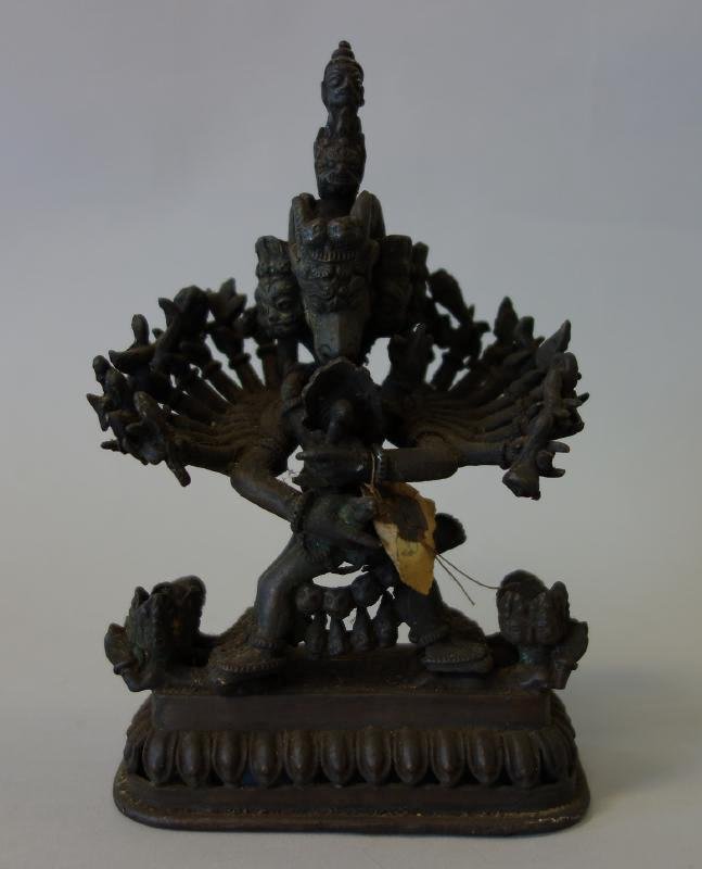 Tibetan Bronze Figure of Vajrapani: A Tibetan or Nepal bronze model of the god Vajrapani, multiple arms holding a child. Measures 7-5/8" high, 4-7/8" wide and 3.25" deep.