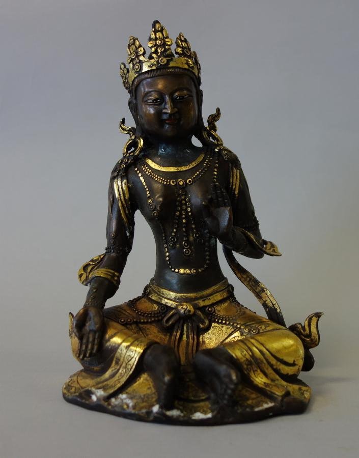 Chinese Gilt Bronze White Tara: A Chinese gilt bronze model of the goddess White Tara. Wearing a gilt crown, her hands in mudra position. Measures 8" high, 6" wide and 4.25" deep.