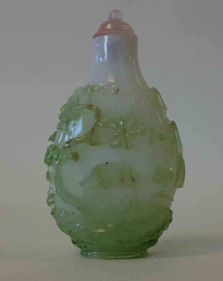 Rare Overlay Cameo Glass Snuff Bottle: A Chinese overlay cameo glass snuff bottle. Late 18th / early 19th century. The white bottle decorated in a transparent pale green glass depicting a figure in a pavilion within a landscape setting. Th