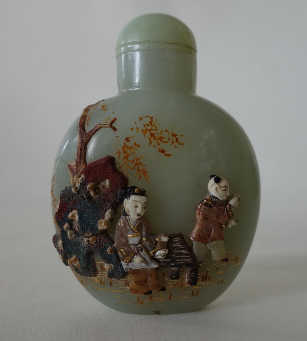 Rare Chinese Carved Jade Snuff Bottle: A rare Chinese celadon jade snuff bottle. Qing Dynasty. Well hollowed, flattened ovoid form. Exceptional raised and mounted polychrome carvings with gilded and abalone details. Depicts a male figure s