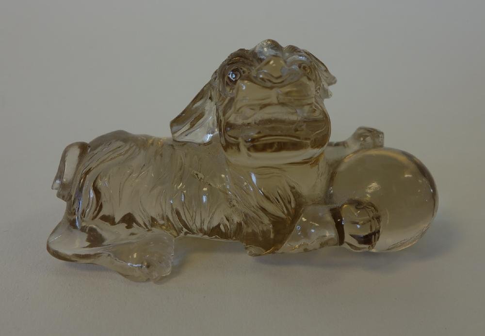 Chinese Rock Crystal Foo Dog With Ball: A Chinese rock crystal model of a foo dog holding a ball. Well carved measuring 3" long, 1.75" high and 1-1/8" deep.