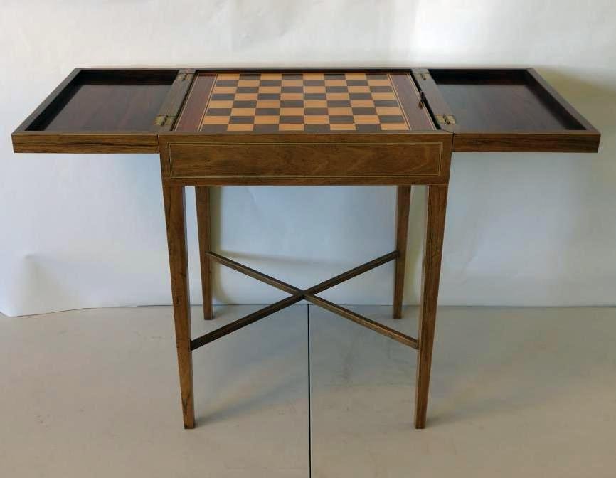 Rolling Block Mahogany Games Table: A mahogany and hardwood games table / box. By Baker Furniture. Rolling block pattern motif on the hinged lids. The interior fitted with a chess / checkers board, the opposite side a dice game...perhap