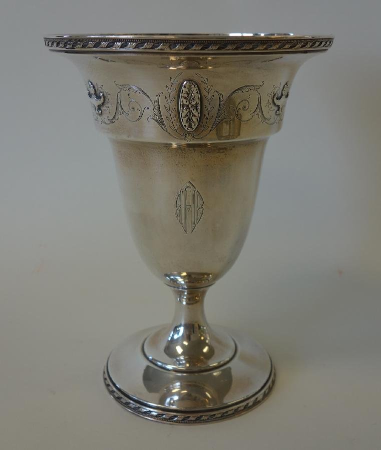 R. Wallace & Sons Sterling Chalice Vase: A sterling silver chalice vase by R. Wallace & Sons. Chased medallions and urns alternating with etched leaves and scrolls. Measures 8" high, 5.75" in diameter. Impressed maker's marks underfoot. Patt