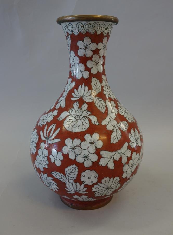Chinese Cloisonne Enamel Vase, Republic Period: A Chinese cloisonne enamel vase. Republic period, c.1915. Iron red body with overall white floral and leaf motif. Impressed China underfoot. Measures 9.5" high. 6.5" in diameter.