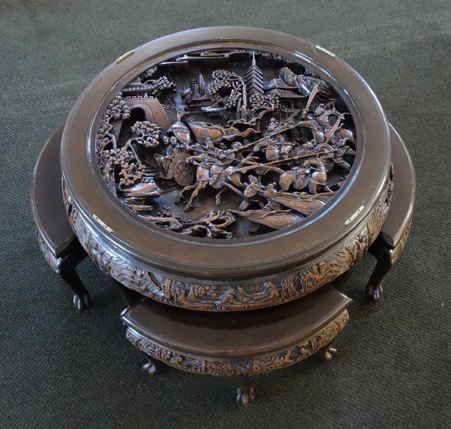 Fine Chinese Carved Tea Table & Stools: A fine Chinese rosewood tea table with four matching triangular shaped stools. The top is well carved in high raised relief depicting a battle scene. Carved apron decorated with figures in landscape s