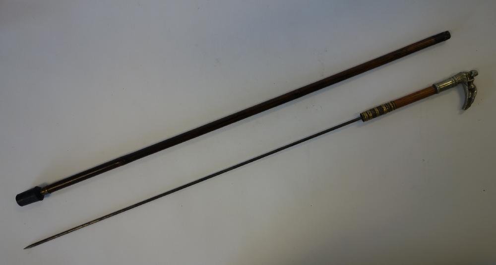 Nude Female Erotic Cane with Sword: A wooden zebrawood cane / walking stick. The pewter handle depicting a nude recumbent female. The handle pulls out to reveal a long pointed sword. The sword blade measures 24.5" long. Brass detailing