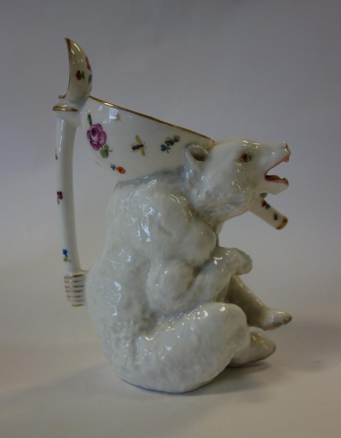 Meissen Porcelain Figural Bear Pitcher: A Meissen porcelain figural pitcher or wine jug in the form of a bear. Hand painted flowers, insects and butterflies. Blue underglaze crossed swords mark on the underside. Measures 8" high x 5.5" x 4.
