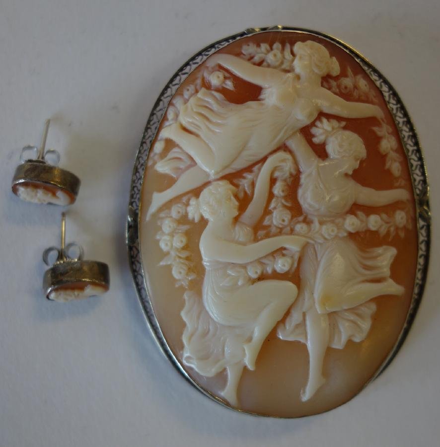 14K Gold Cameo Brooch & Earrings, Three Graces: A large carved shell cameo depicting The Three Graces. Mounted in a 14K white gold filigree brooch pin / pendant. Measures 2.5" x 1-7/8". Together with a pair of similar matching pierced earrings.