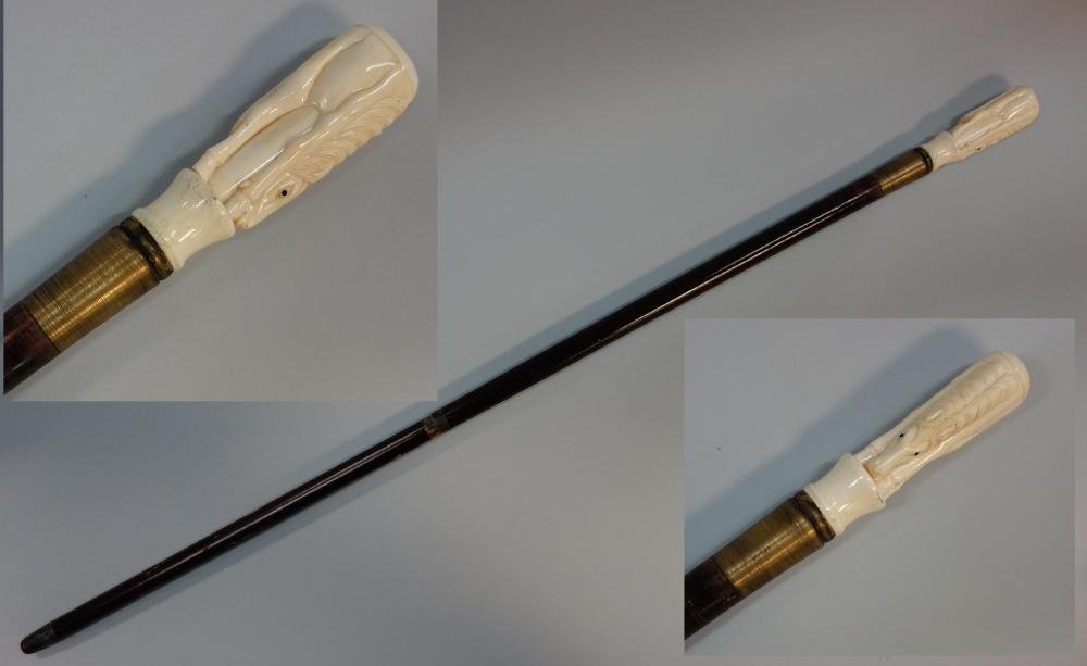 Antique Walrus Ivory Horse Handled Cane: An antique carved walrus ivory handled cane / walking stick. c.1900. The handle in the form of a bending horse with black glass eyes. Wood shaft, brass collar and ferrule. Measures 39.25" long. NOTE:
