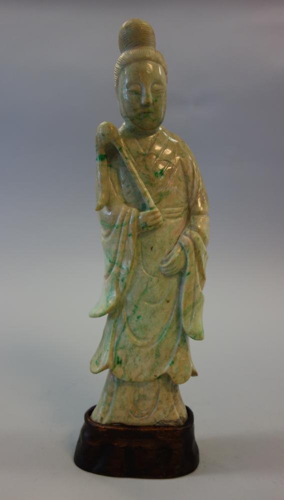 Chinese Carved Jade Guanyin Female Diety: A fine Chinese jade model of the female deity, Guanyin. Well carved female goddess in a long robe holding a staff in her hand. Mounted in a wood stand. Overall measurement 11.5" high, 3.5" wide and 1-