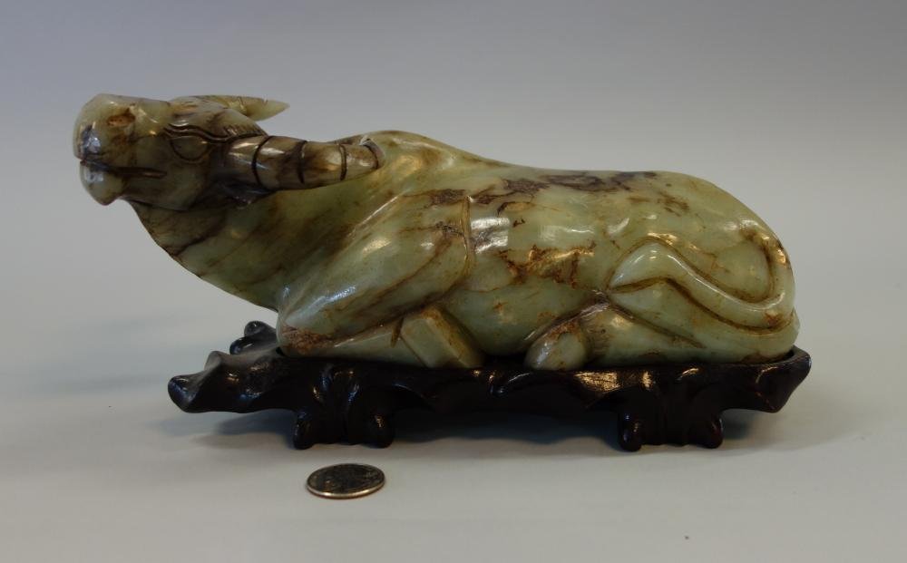 Chinese Jade Ox Carving: A Chinese jade carving of a recumbent ox. Measures 9.5" long, 4" wide, 3.75" high. With fitted wood stand.