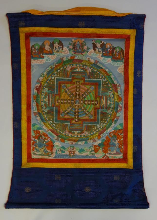Tibetan Thangka Painting, Buddhist Deity: A Tibetan Thangka painting on silk. Depicts a small central medallion of a Buddhist Deity surrounded by concentric circles containing other deities. Further decorated with Buddha, gods, animals, mytho