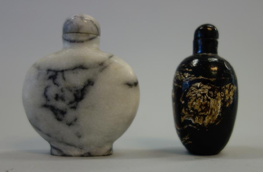 2 Chinese Snuff Bottles, Jade & Horn: Two Chinese snuff bottles. A white jade bottle with black inclusions, flattened ovoid form measuring 2.5" high, 2" wide. Together with a horn snuff bottle, etched and carved with abstract designs, 2-3