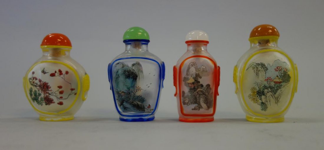 4 Chinese Inside Painted Snuff Bottles: A group of four Chinese opaque glass snuff bottles with inside painted landscape and floral scenes. Enamel painted overlay outlining the bottles. Each with raised animal faced side handles. 2.5" high.
