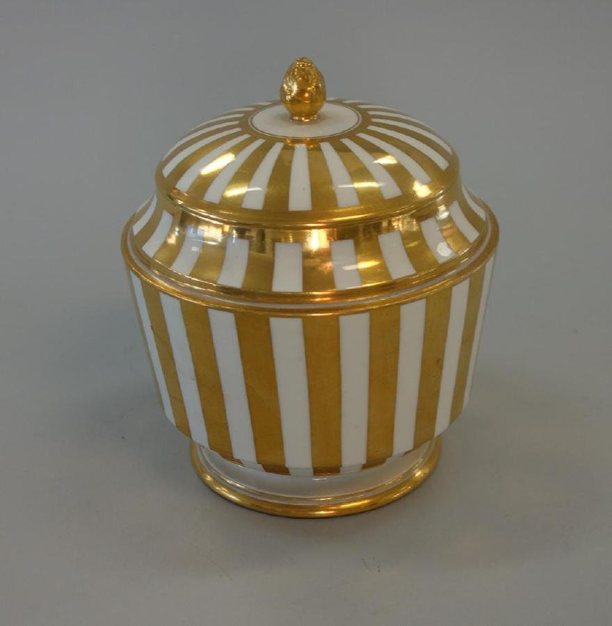 Augarten Royal Vienna Porcelain Biscuit Jar: An Austrian porcelain biscuit jar. Beehive mark for Augarten / Royal Vienna. White porcelain with overall gilded enamel striping. Gilded finial. Measures 5.75" high, 5" in diameter. NOTE: minor nick t