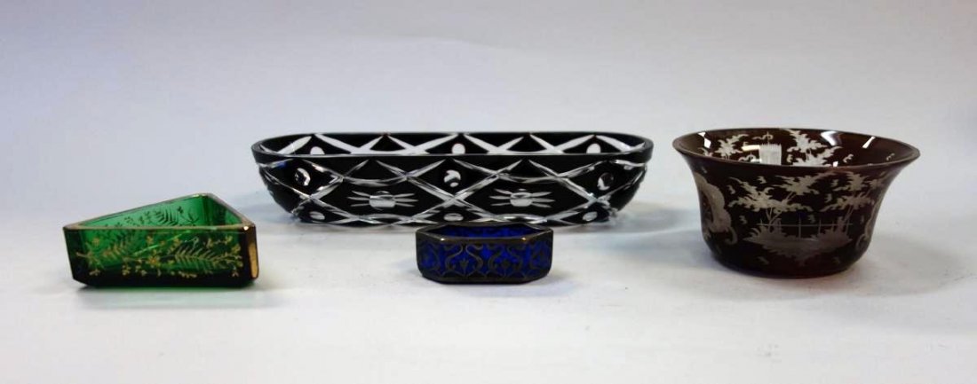 4 Bohemian Art Glass Dishes, Salts +: A group of four Bohemian art glass objects. Comprised of a black cut to clear oblong dish, 8.75" long, a ruby red bowl etched with a castle and a landscape, a cobalt blue glass open salt cellar with s