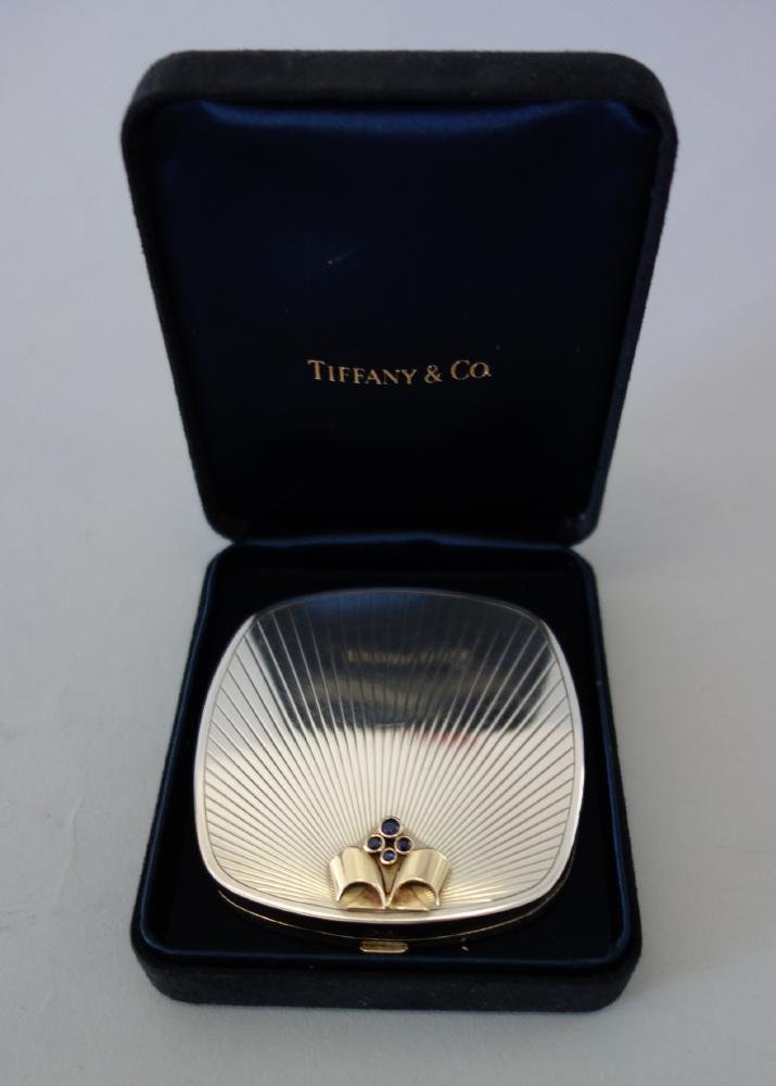 Tiffany & Co Sterling, Gold & Sapphire Compact: A Tiffany & Co sterling Art Deco compact. Etched sunray motif. The compact adorned with four deep blue sapphires and 14K gold formed as budding flowers and leaves. Interior with mirror and powder well