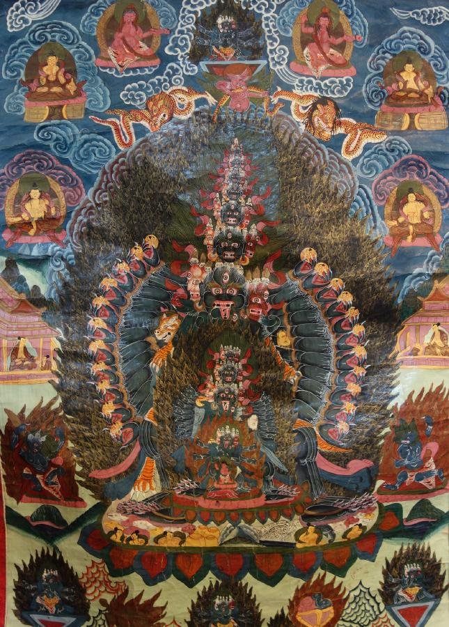 Tibetan Thangka Painting, Buddhist Deities: A Tibetan Thangka painting on silk. Depicts Buddhist deities and animals. Well painted and detailed, the painting measures 33" x 23". Mounted on a blue brocade stitched embroidered fabric with gold an