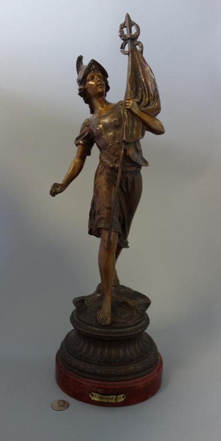 French Bronzed Spelter Model, L'Honneur: A French bronzed spelter model of a female warrior holding a flag. Titled on the base, L'Honneur. Overall height on wood base, 22". NOTE: the lower hand appears to be missing a sword or rod, slight cr