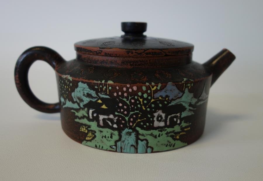 Chinese Yixing Enameled Clay Teapot, Signed: A Chinese Yixing Zisha red clay teapot. Black glaze with polychrome enamel decoration. Signed underfoot. Measures 3.25" high, 7.25" wide from end of handle to end of spout. CONDITION NOTE: Older chip 