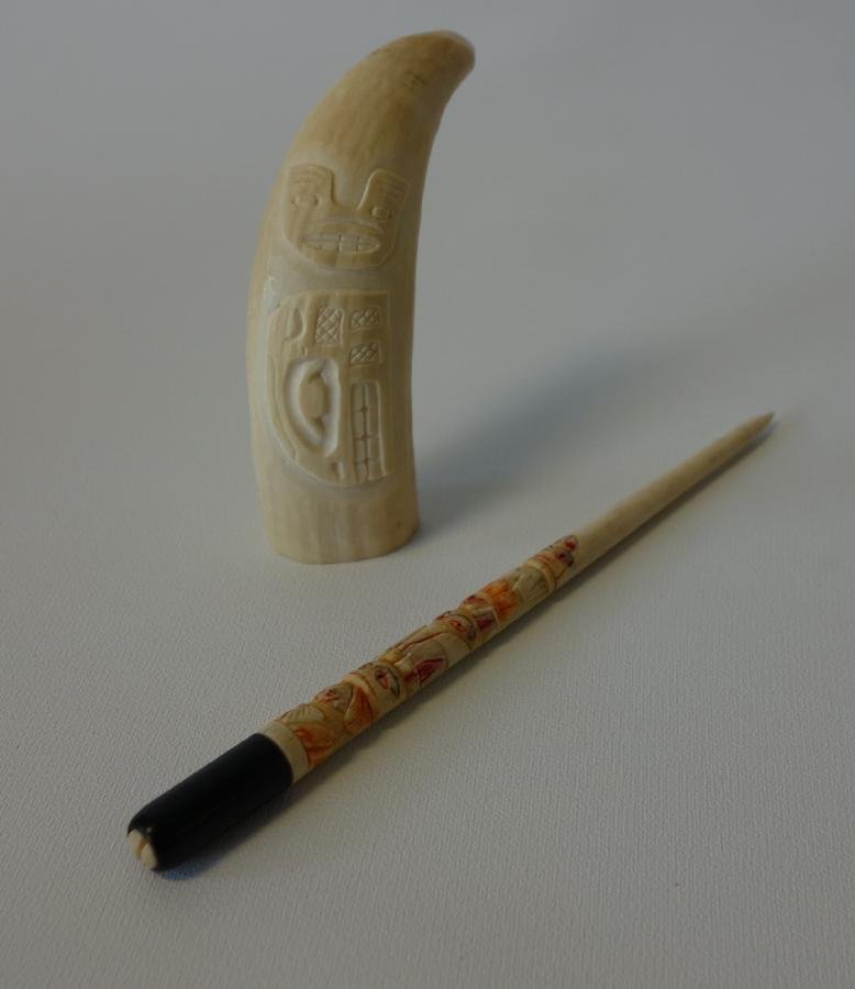 Alaskan Carved Whale's Tooth & Totem Quill Pen: A carved Alaskan / Eskimo whale's tooth. Carved with a Native American motif, 3.5" high. Together with a polychrome carved bone totem quill pen, 6-1/8" long.