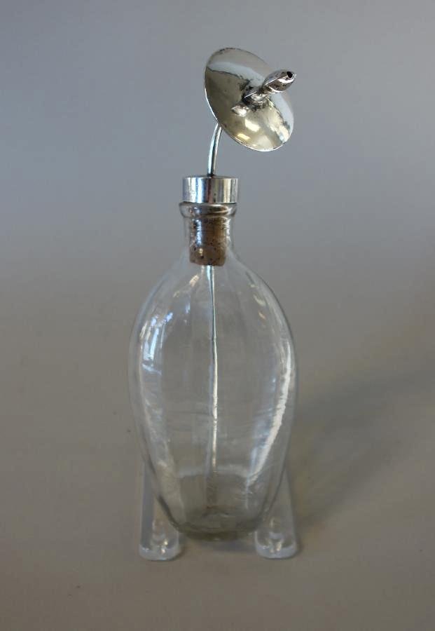 18thc Glass & Silver Baby Bottle, Pacifier Nipple: An antique glass baby milk bottle, late 18th / early 19th century. Oval formed and ribbed bottle with a coin silver cap lid and curved pacifier nipple. The side of the cap with maker's initials D.T.G.