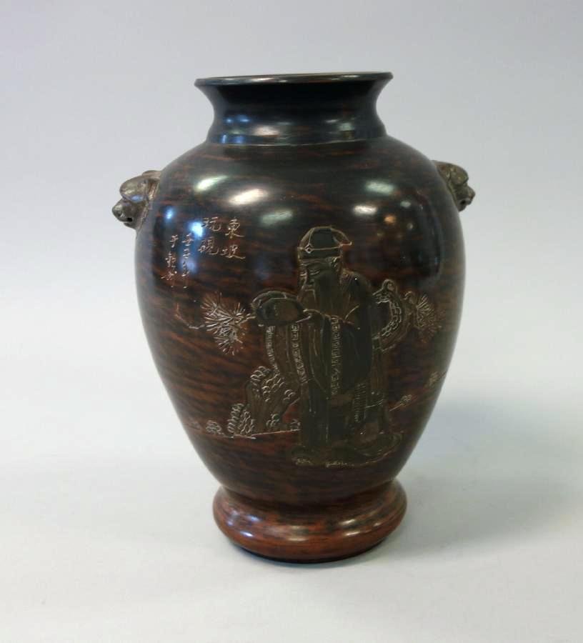 Chinese Porcelain Vase, Signed & Sealed: A Chinese brown ground porcelain vase. Etched and raised decoration depicting an Elder male scholar within a landscape setting. Chinese calligraphy characters, possibly indicating a poem. Lion faced s