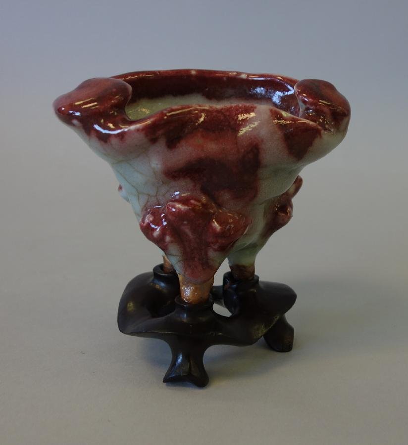Chinese Crackle Glaze Porcelain Libation Cup: A Chinese crackle glaze celadon porcelain libation wine cup. Archaistic tripod footed form with Lang-yao (ox-blood) / Sang de Boeuf glaze. Measures 3-3/8" high, 4.5" wide, 3.25" deep. With fitted rose