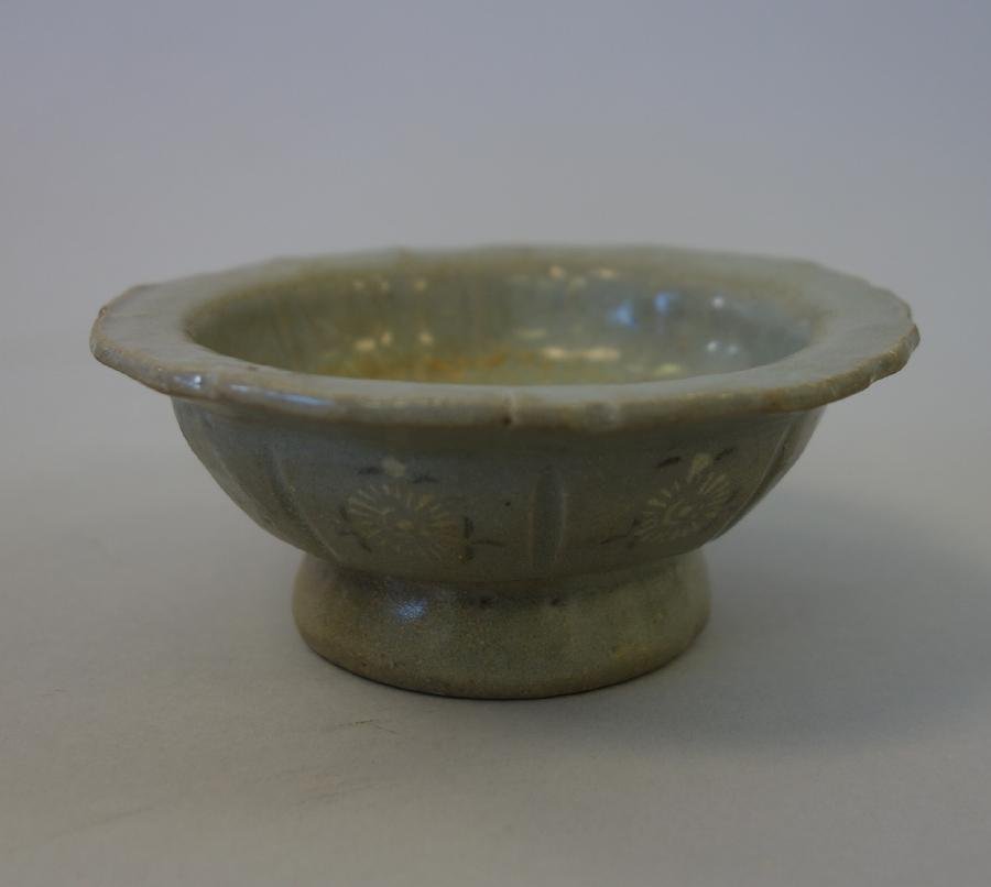 Korean Koryo Dynasty Inlaid Footed Dish: A Korean Koryo Dynasty inlaid footed dish. Celadon footed dish with scalloped edge. The exterior decorated in white slip with floral medallions. Measures 4-1/8" diameter, 1.75" high. CONDITION NOTE: a