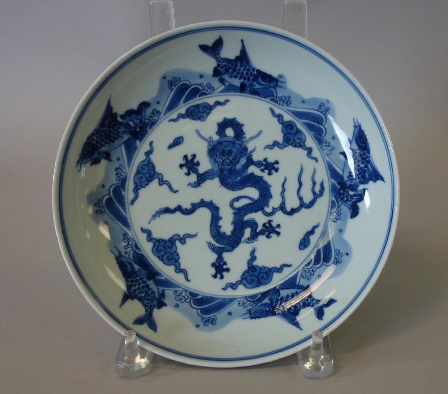 Chinese Porcelain Shallow Bowl, Ming Mark: A Chinese blue and white porcelain shallow Ming-Style bowl. The underside bears a six character calligraphy mark for Ming Dynasty, Xuande reign. The interior depicts a five claw dragon among stylized